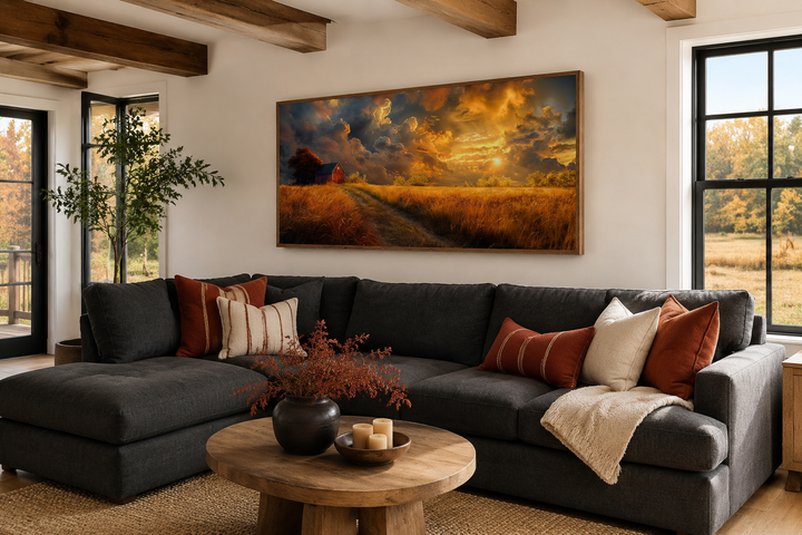 Old red barn in autumn sunset framed farmhouse canvas wall art hanging above a dark gray sofa.