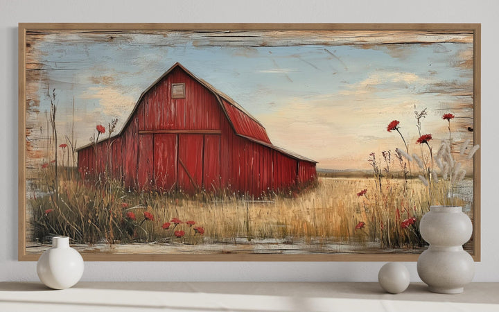 Old red barn on weathered wood canvas wall art in a rustic frame above a shelf with white vases.