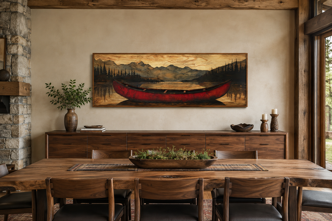 Long horizontal framed canvas wall art of a red canoe painted on a wood-textured mountain landscape.