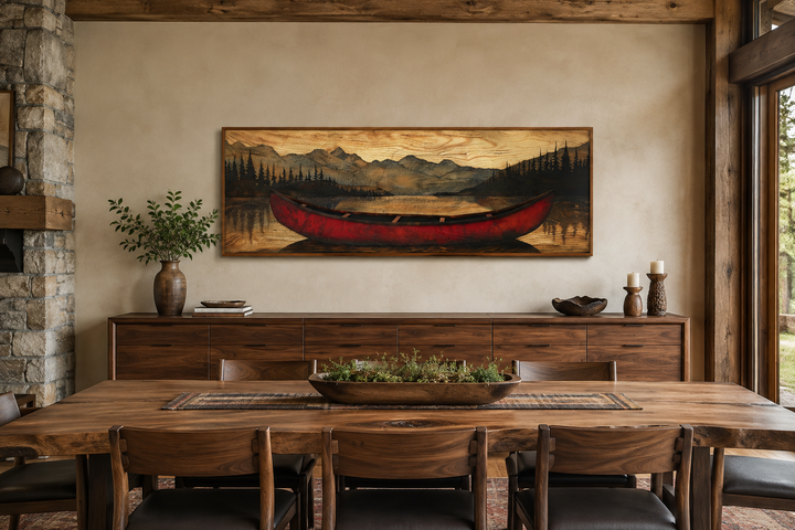 Long horizontal framed canvas wall art of a red canoe painted on a wood-textured mountain landscape.