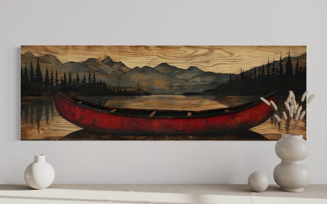 Long horizontal wall art of a red canoe on a lake with mountains painted on a wood grain background.