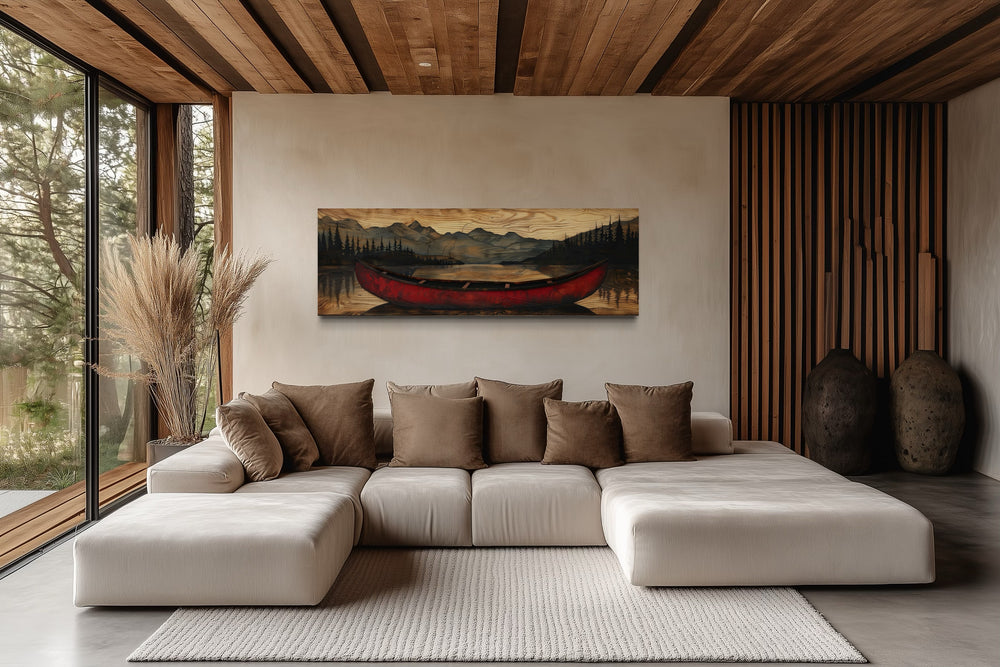 Old red canoe painted on wood long horizontal framed canvas wall art above a modern sectional sofa.