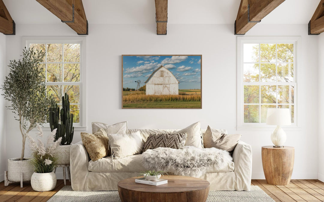 Old weathered white barn with windmill framed canvas wall art in a farmhouse living room.
