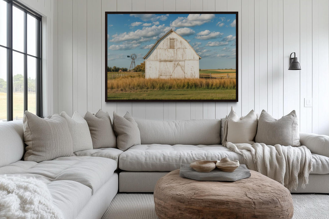 Old weathered white barn with windmill framed canvas wall art in a farmhouse living room.