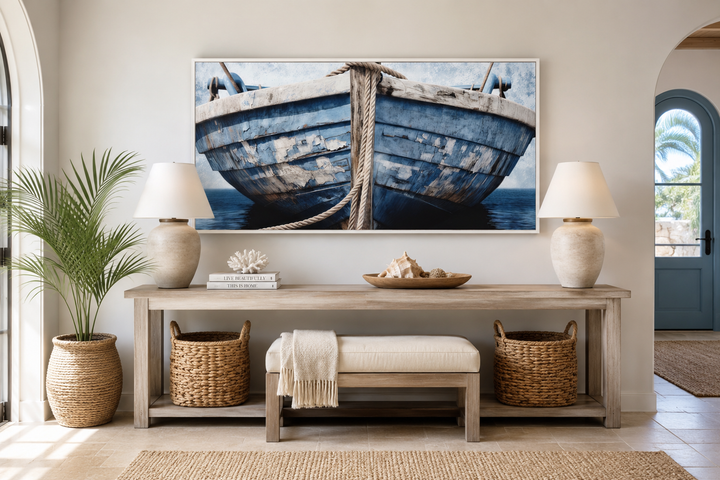 Rustic blue and white boat framed canvas wall art displayed above a console table in a beach house.