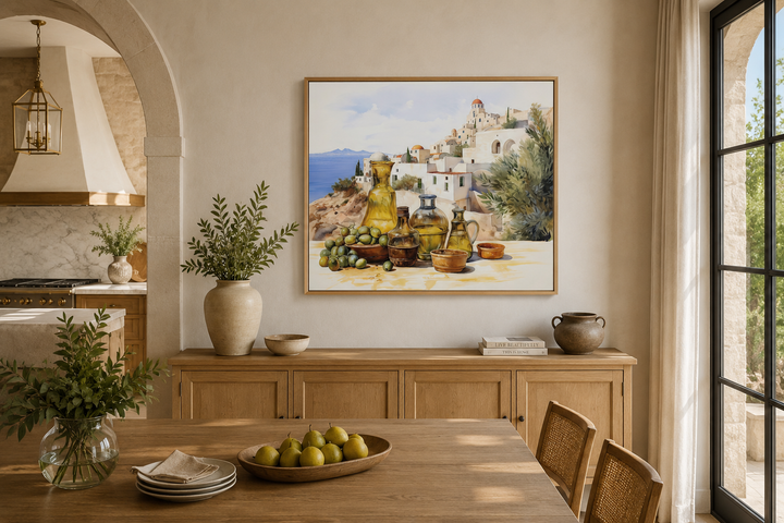 Framed watercolor canvas of a Greek landscape with olives and oil bottles on a kitchen wall.
