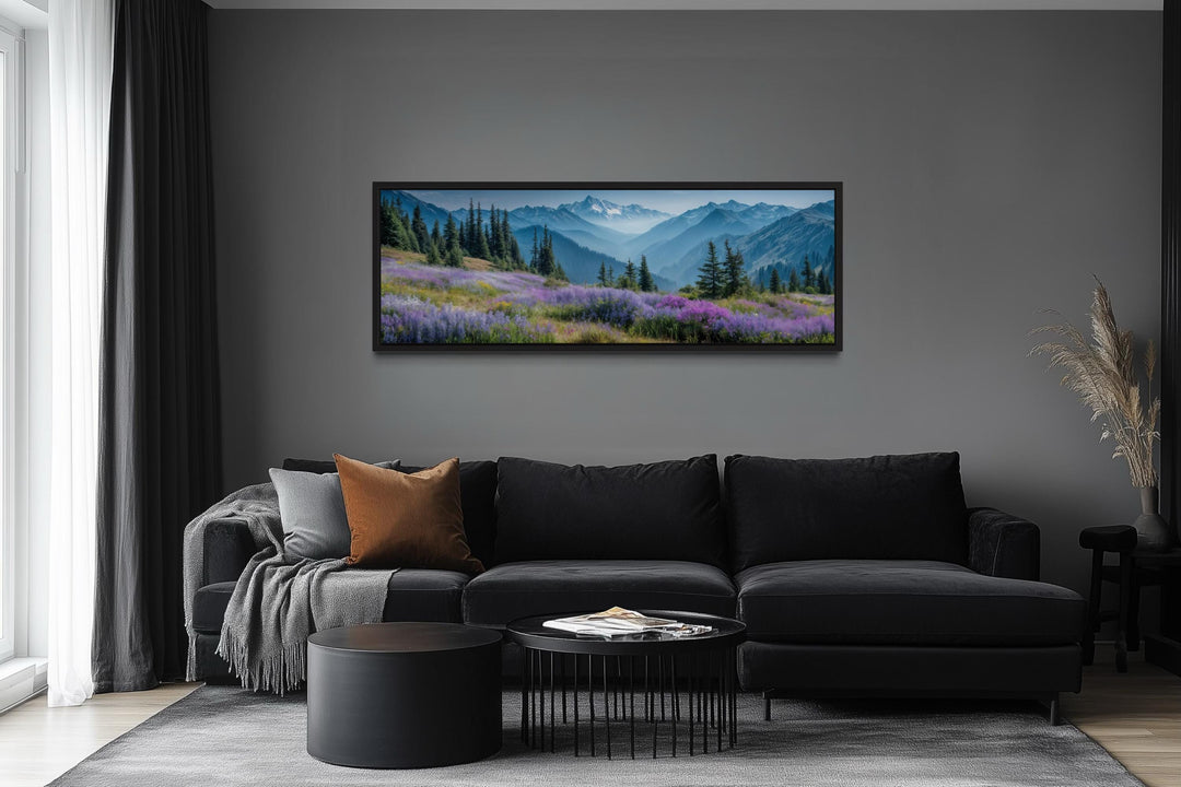 Panoramic canvas wall art of Olympic National Park mountains and wildflowers over a black sofa.