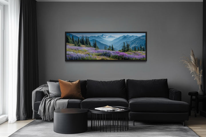Panoramic canvas wall art of Olympic National Park mountains and wildflowers over a black sofa.