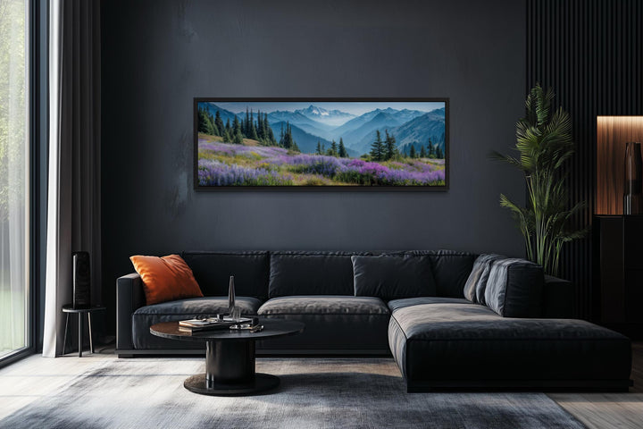 Panoramic Olympic National Park canvas wall art with purple wildflowers above a dark grey sofa.