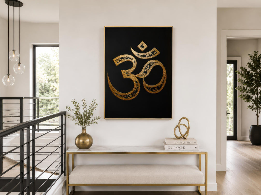 A vertical gold and black Om symbol canvas print hangs above a marble console table in a modern home.