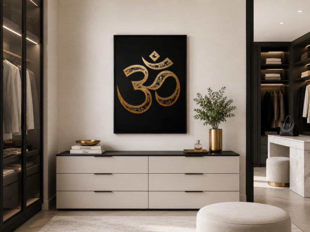 Gold and black Om symbol canvas wall art centered above a modern white dresser in a luxury closet.