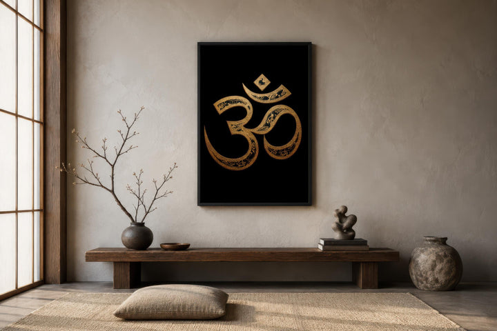 A framed gold Om symbol on a black canvas hangs in a minimalist, zen-style meditation room.