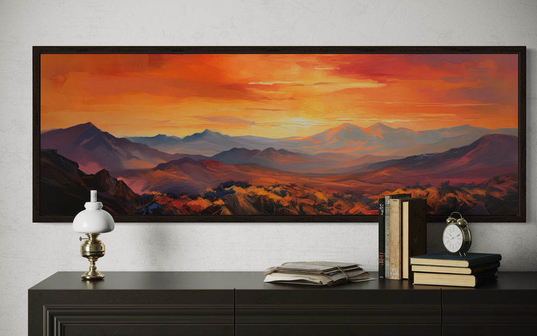 Orange mountain sunset horizontal framed canvas wall art displayed above a dark console table.