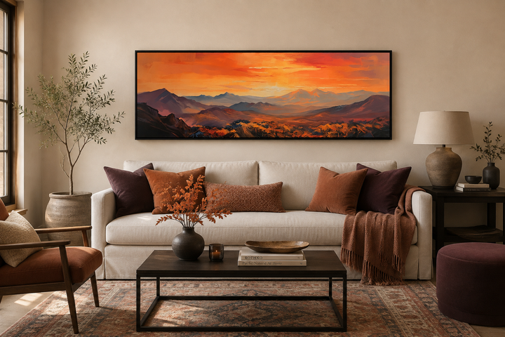 Orange mountain sunset horizontal framed canvas wall art hanging above a white couch in a room.