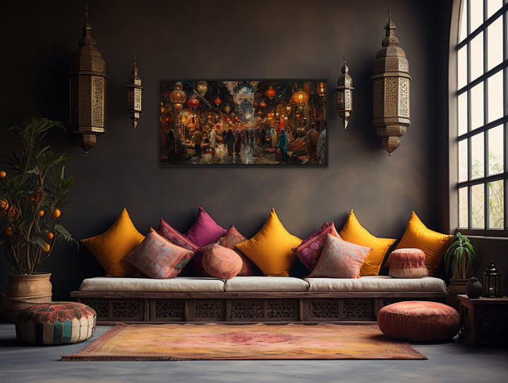 Framed canvas painting of a bustling oriental bazaar market hanging in a rustic living room.