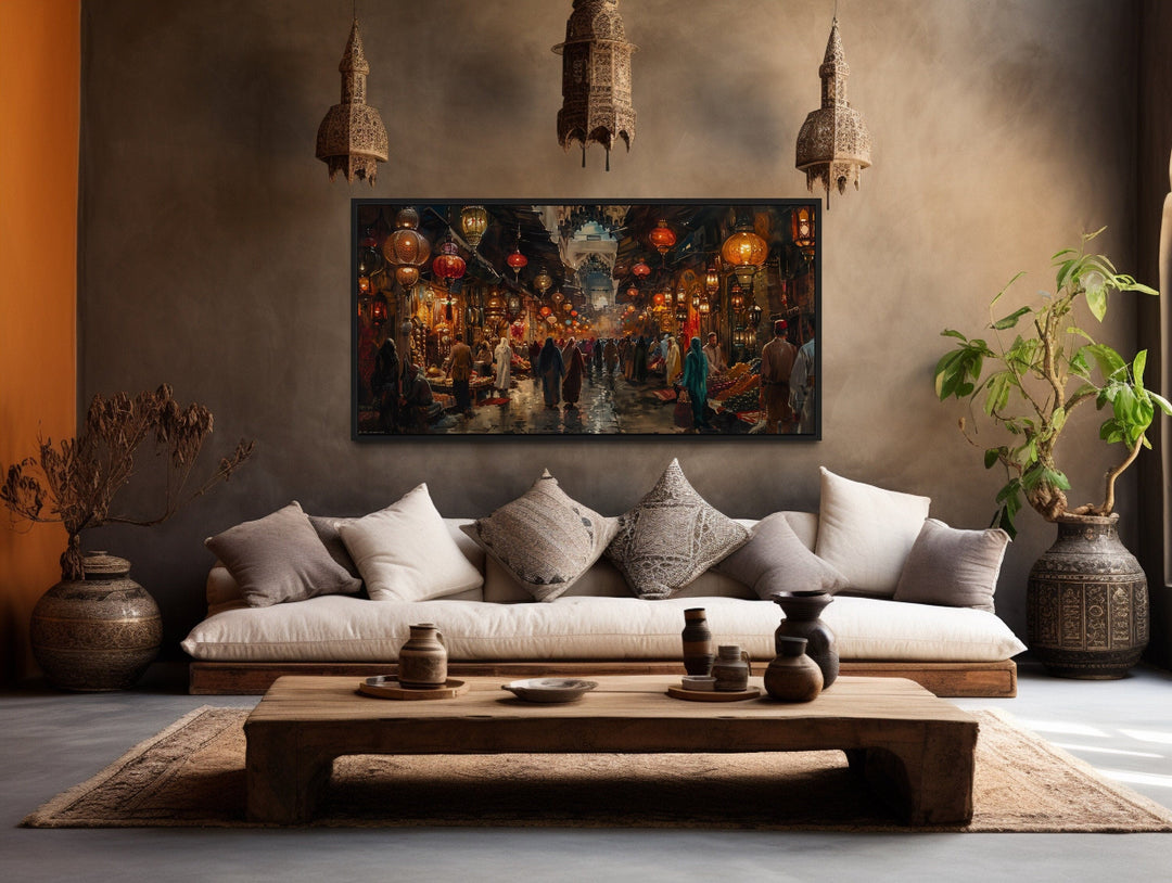 Framed canvas painting of a bustling oriental bazaar market hanging in a rustic living room.