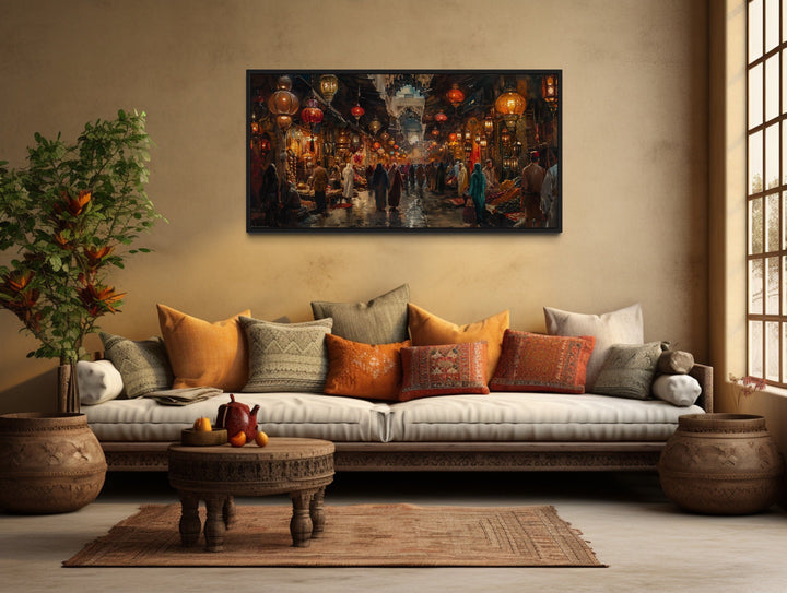 Oriental bazaar framed wall art above a rustic sofa with colorful pillows and a wooden coffee table.