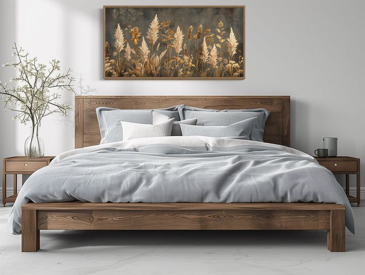 Pampas grass on grey background rustic neutral framed canvas wall art above a wooden bed.