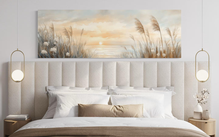 Pampas grass on the beach coastal horizontal wall art hanging above a bed in a neutral bedroom.