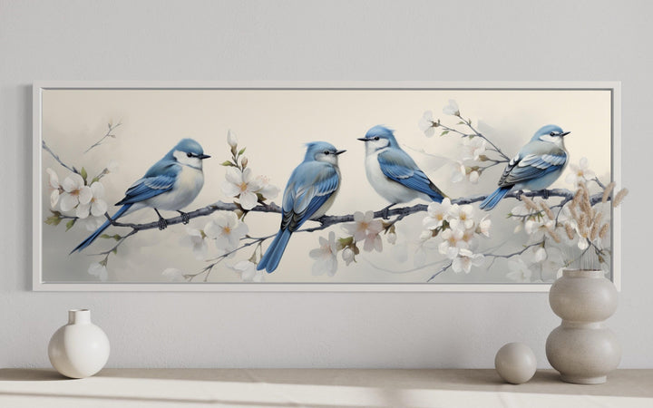 Panoramic watercolor wall art of four blue birds perched on a flowering branch in a white frame.