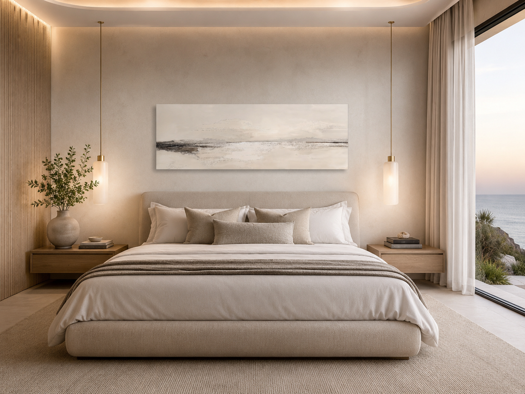 Panoramic coastal landscape canvas wall art in neutral tones hanging above a king-sized bed.
