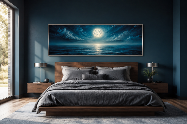 Panoramic navy blue ocean and moon wall art hanging above a modern wooden bed in a dark blue room.