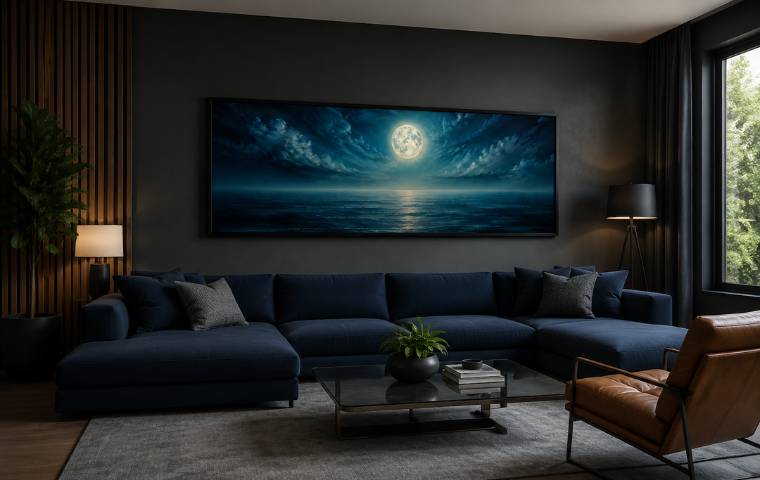 Panoramic navy blue ocean and moon in night sky wall art hanging above a sofa in a modern room.