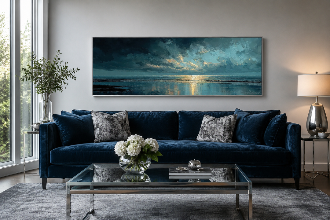 Panoramic ocean wall art with blue, grey, and gold sunset over a dark sofa in a modern living room.