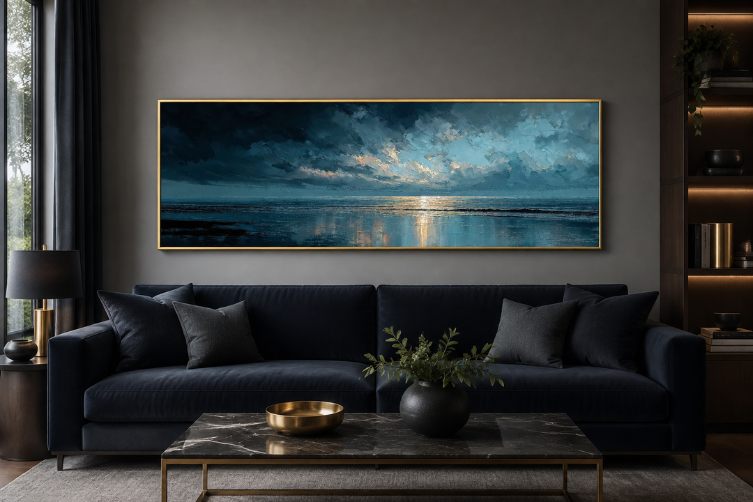 Panoramic ocean wall art with blue-gray clouds and golden sunset reflections in a gold frame.
