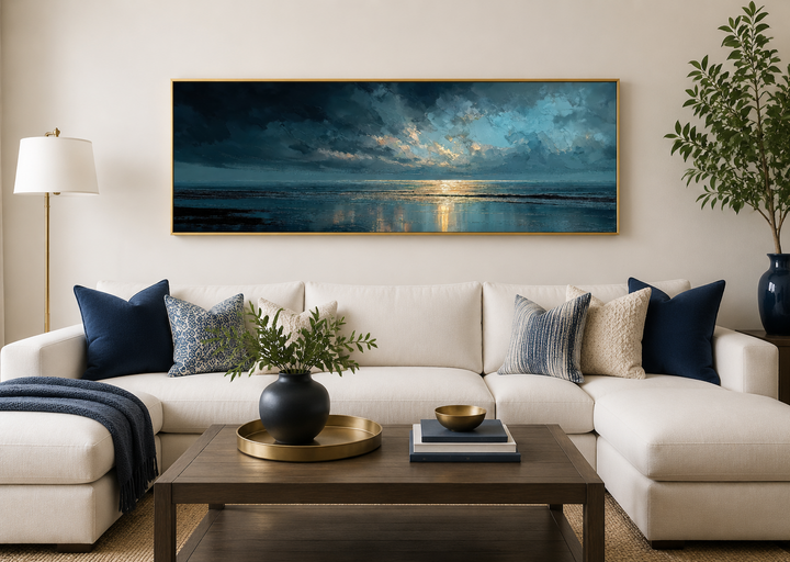 Panoramic ocean wall art with blue, grey, and gold sunset over a sofa in a modern living room.