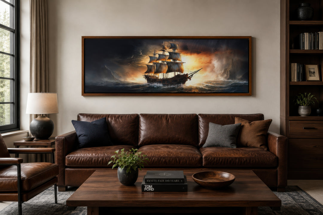 Panoramic framed canvas wall art of a pirate ship on a stormy ocean above a brown leather sofa.