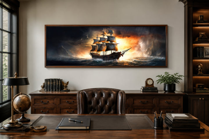 Panoramic framed canvas wall art of a pirate ship in a stormy ocean above a wooden office desk.