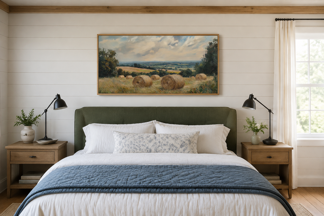Pastoral hay field framed canvas wall art above a bed in a farmhouse style bedroom.