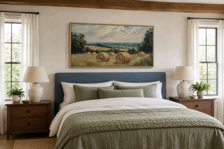 Pastoral hay field framed canvas wall art above a bed in a farmhouse-style bedroom.