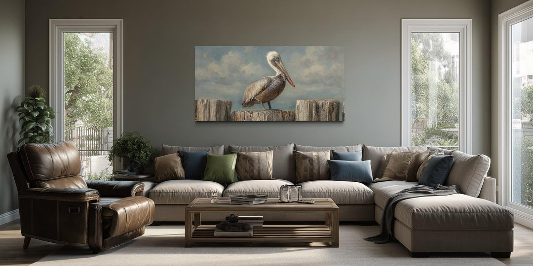 Pelican Standing On Wooden Posts Coastal Canvas Wall Art displayed above a sofa in a living room.