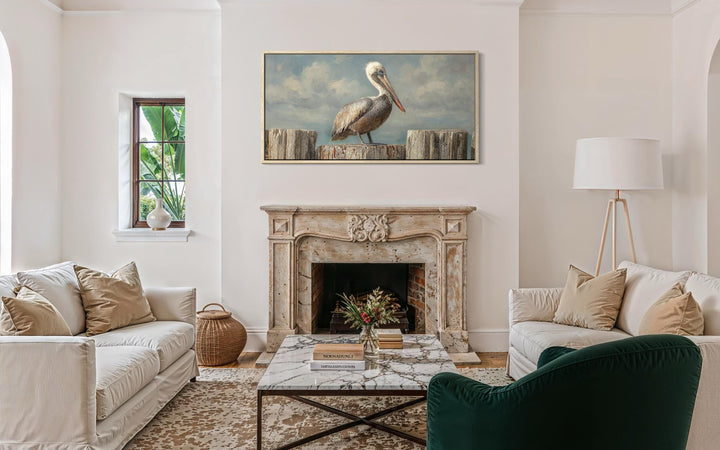 Coastal canvas wall art featuring a pelican on wooden posts above a fireplace in a living room.