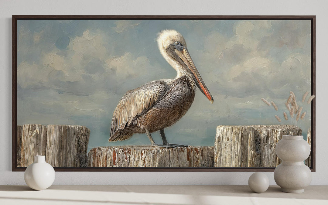 Horizontal canvas wall art of a pelican on wooden posts in a soft, coastal-themed painting.
