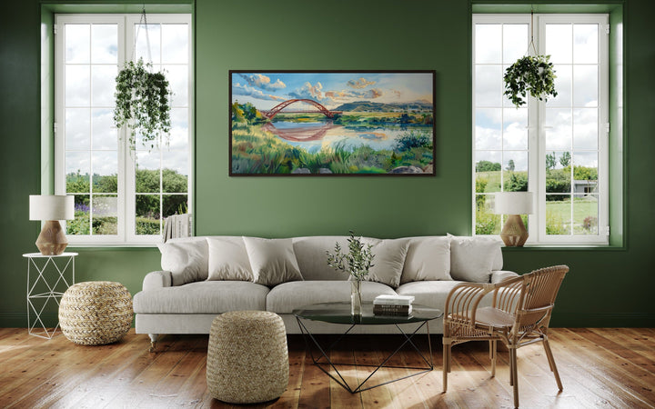 Pennybacker Bridge watercolor painting wall art in a dark frame above a sofa in a green living room.