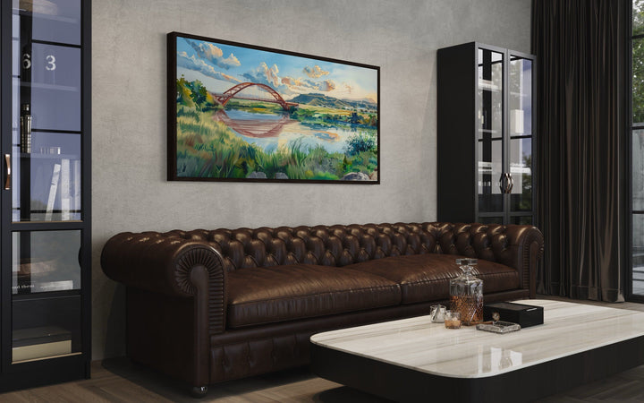 Pennybacker Bridge watercolor painting wall art in a black frame above a brown leather sofa.