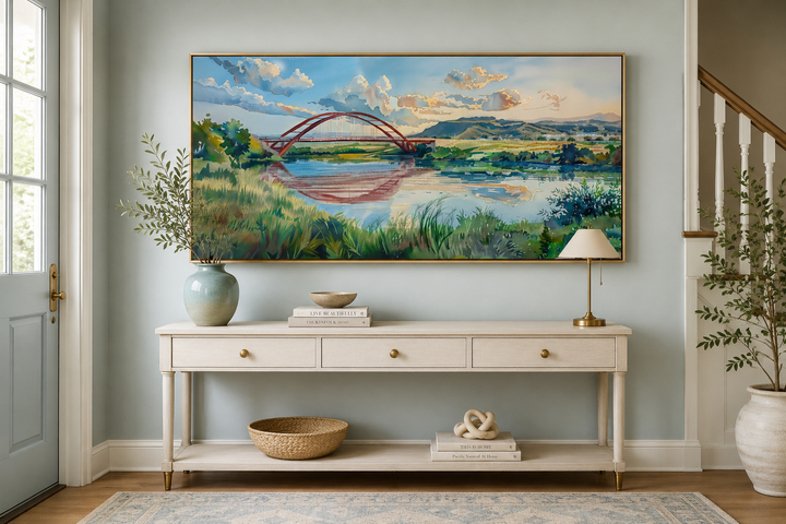 Pennybacker Bridge watercolor painting in a gold frame above a white console table in a home entryway