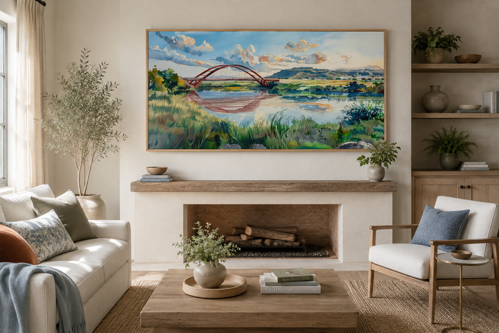 Pennybacker Bridge watercolor painting wall art in a wooden frame above a living room fireplace.