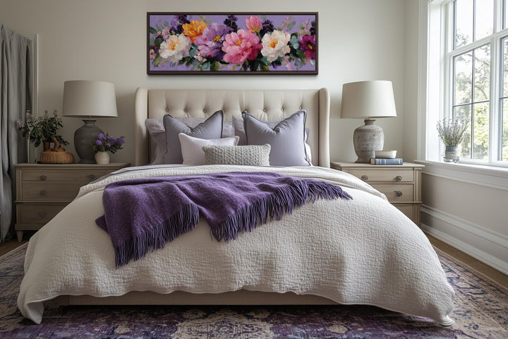 A long horizontal canvas painting of colorful peonies hangs above a bed with purple accents.
