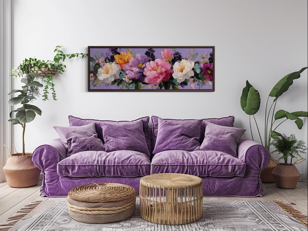 Horizontal canvas wall art of colorful peonies in a purple-themed living room above a velvet sofa.