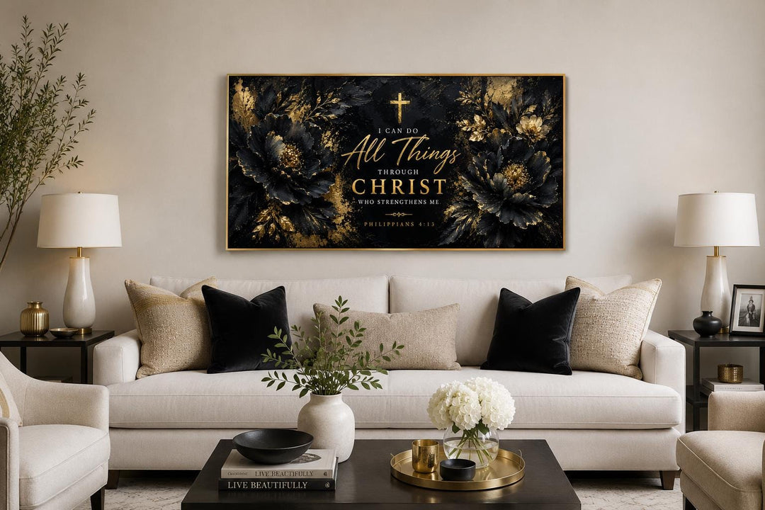 Philippians 4:13 Christian wall art with gold script on black floral background above a white sofa.