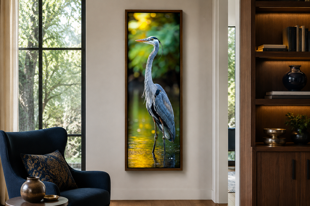 Vertical narrow wall art of a blue heron standing in water, framed in wood in a modern living room.