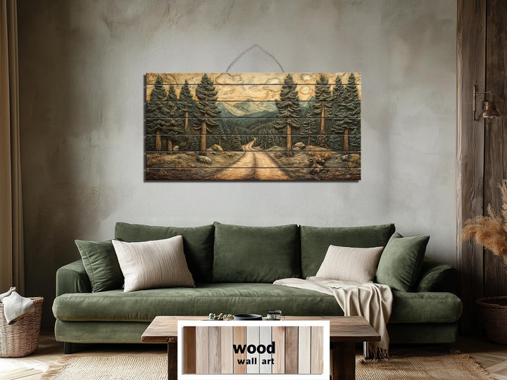 Pine forest landscape printed on a horizontal distressed wood wall art piece above a green sofa.
