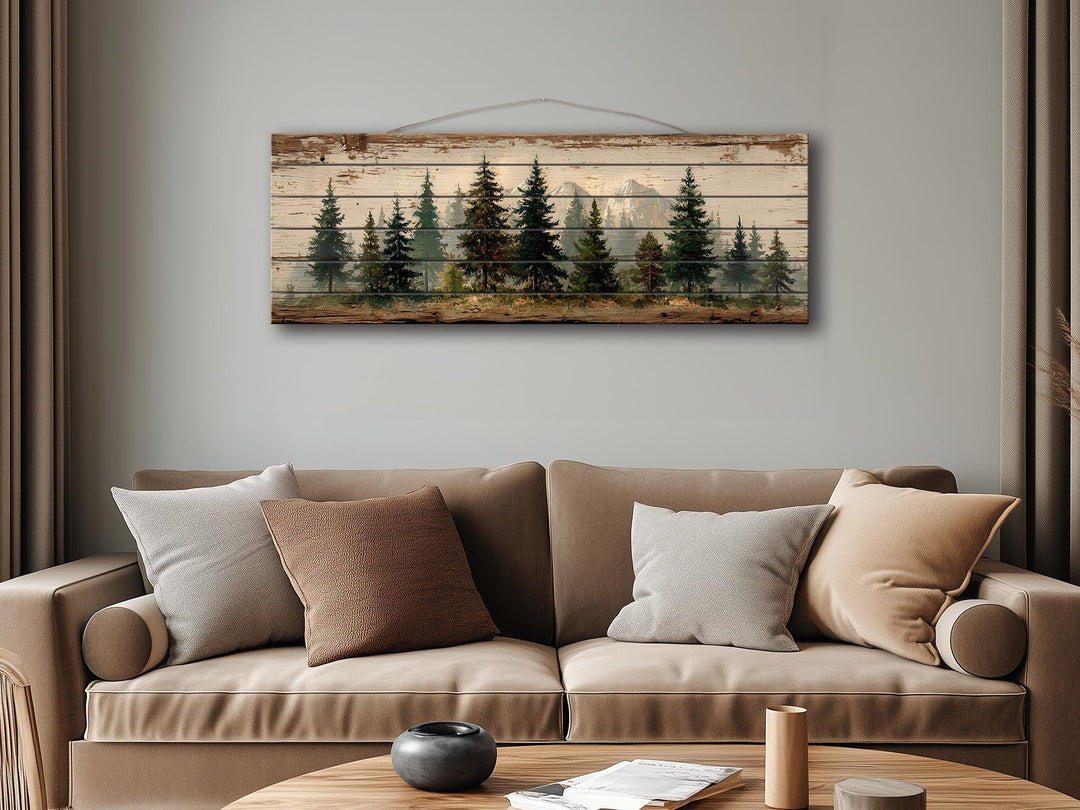 Rustic wood wall art featuring a distressed pine forest and mountain landscape over a tan sofa.