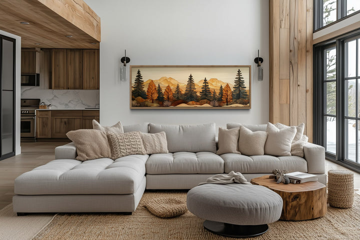 Pine forest wood mosaic wall art in a long horizontal frame hanging above a light gray sectional.