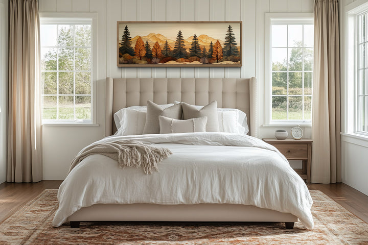 Pine forest wood mosaic painting in a long horizontal frame hanging above a bed in a bedroom.