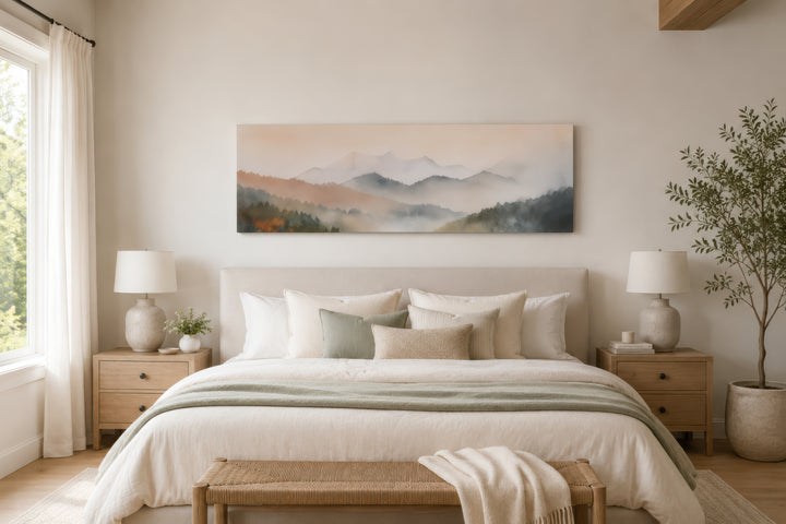 A wide canvas print of a pastel pink and green mountain landscape hangs above a neutral-toned bed.